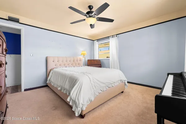 a bedroom with a bed and a ceiling fan