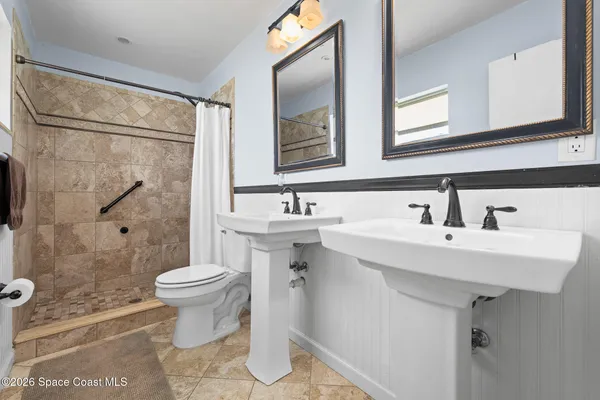 a bathroom with a sink toilet a mirror and shower