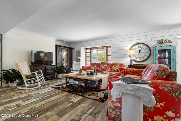 a living room with furniture a clock and a flat screen tv