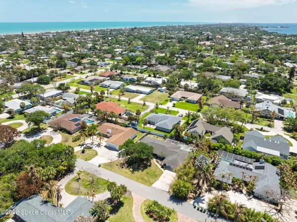 an aerial view of a city with lots of residential buildings ocean and mountain view in back