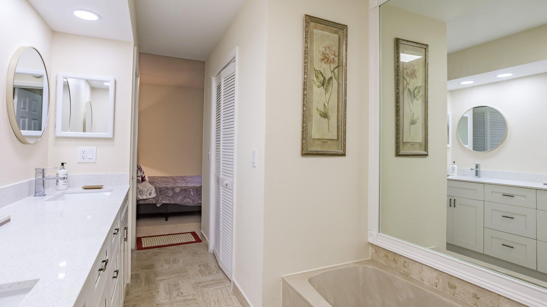 7460 La Paz Boulevard, Unit 208 Boca Raton, FL 33433 - Photo 14 of 23 a en suite bathroom with a granite countertop sink and a mirror