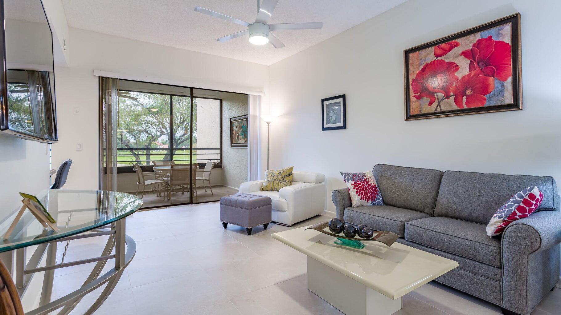 7460 La Paz Boulevard, Unit 208 Boca Raton, FL 33433 - Photo 2 of 23 a living room with furniture and a floor to ceiling window
