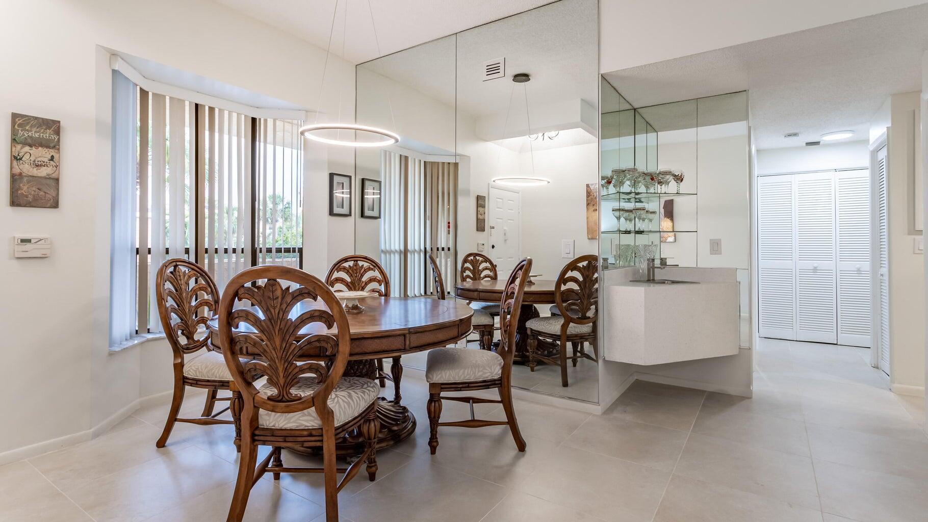 7460 La Paz Boulevard, Unit 208 Boca Raton, FL 33433 - Photo 7 of 23 a view of a dining room with furniture and chandelier