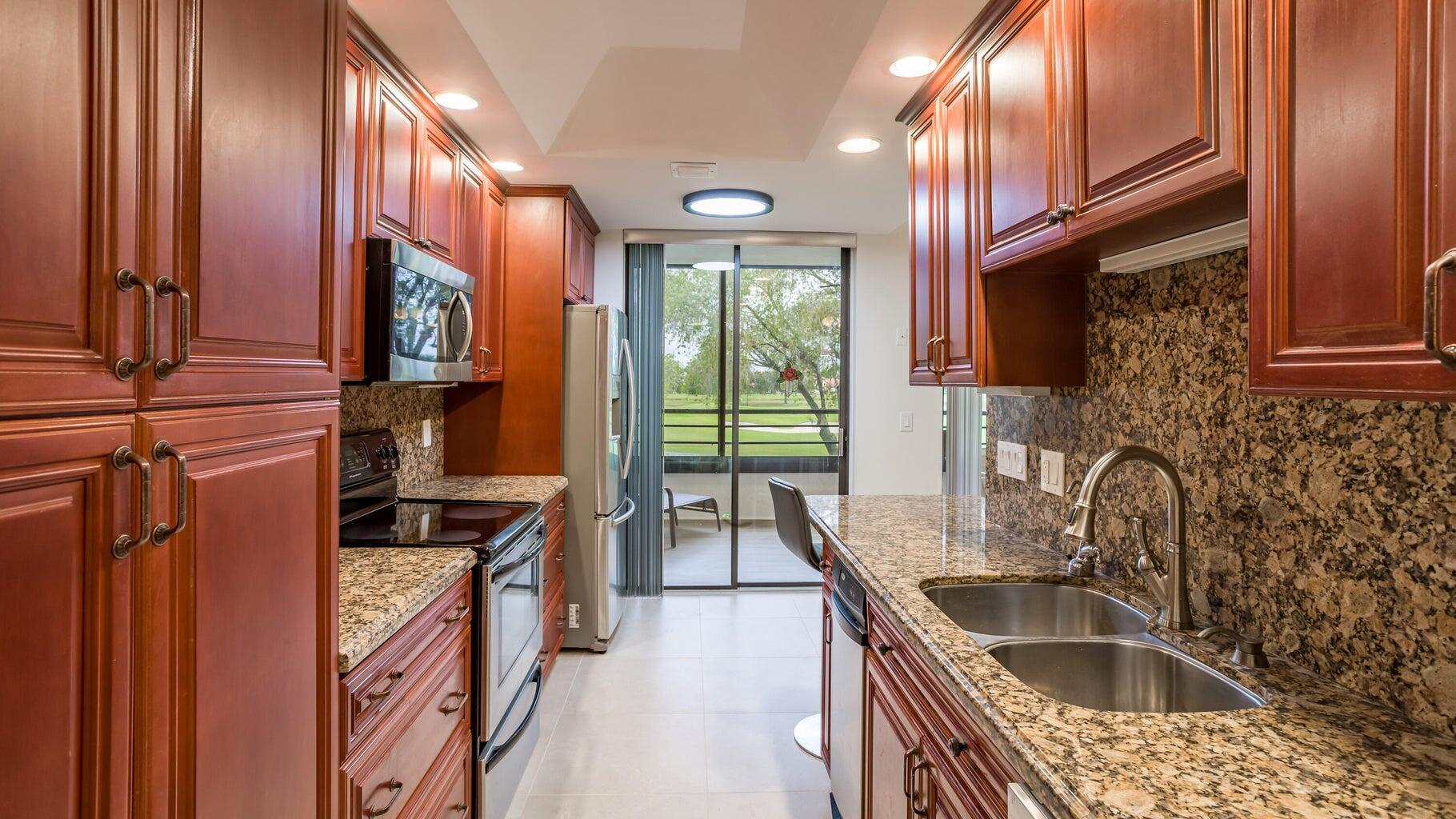 7460 La Paz Boulevard, Unit 208 Boca Raton, FL 33433 - Photo 10 of 23 a kitchen that has a sink and a stove