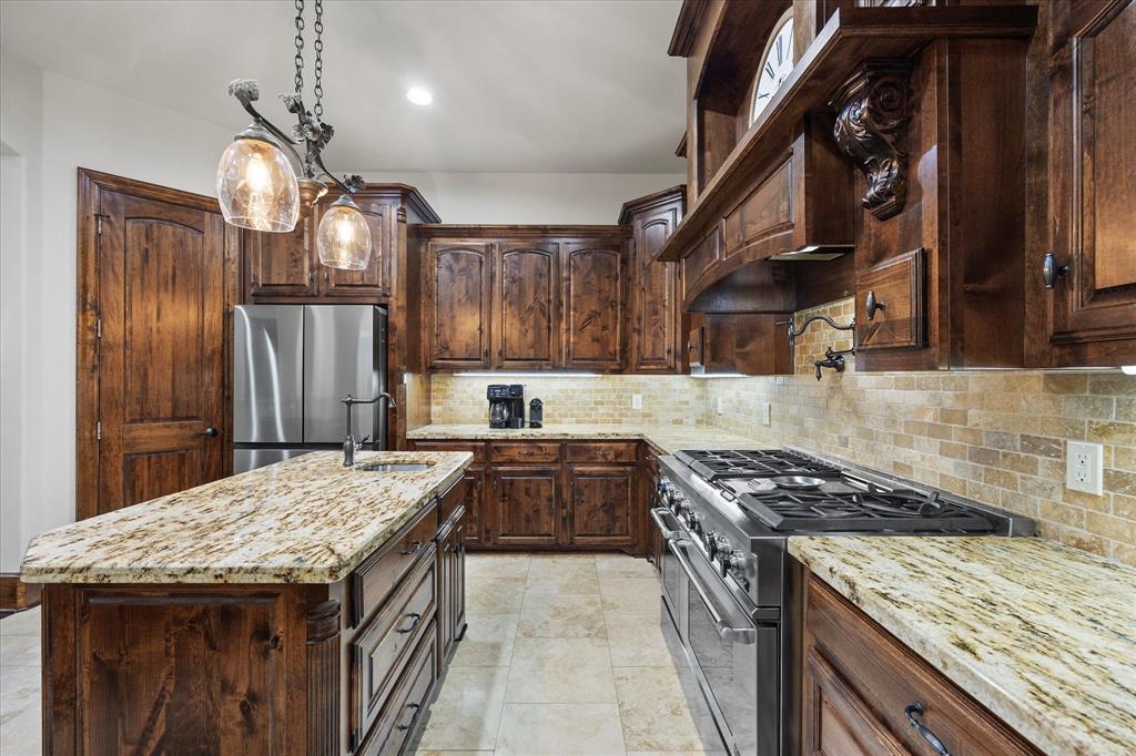 1704 White Road Heath, TX 75032 - Photo 15 of 28 a kitchen with granite countertop a stove a sink a refrigerator and wooden cabinets