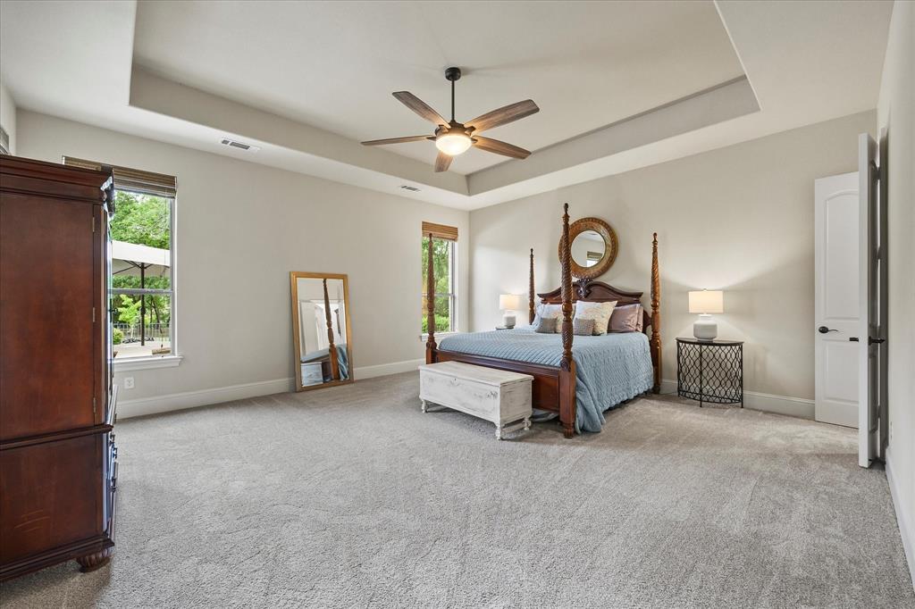 1704 White Road Heath, TX 75032 - Photo 18 of 28 a spacious bedroom with a bed and a chandelier