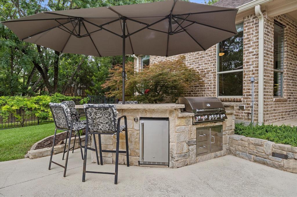 1704 White Road Heath, TX 75032 - Photo 10 of 28 a view of an outdoor sitting area with a table and chairs under an umbrella