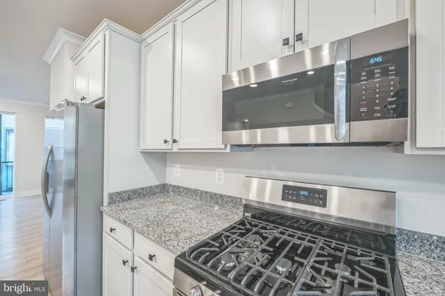 a kitchen with stainless steel appliances granite countertop a sink and a refrigerator
