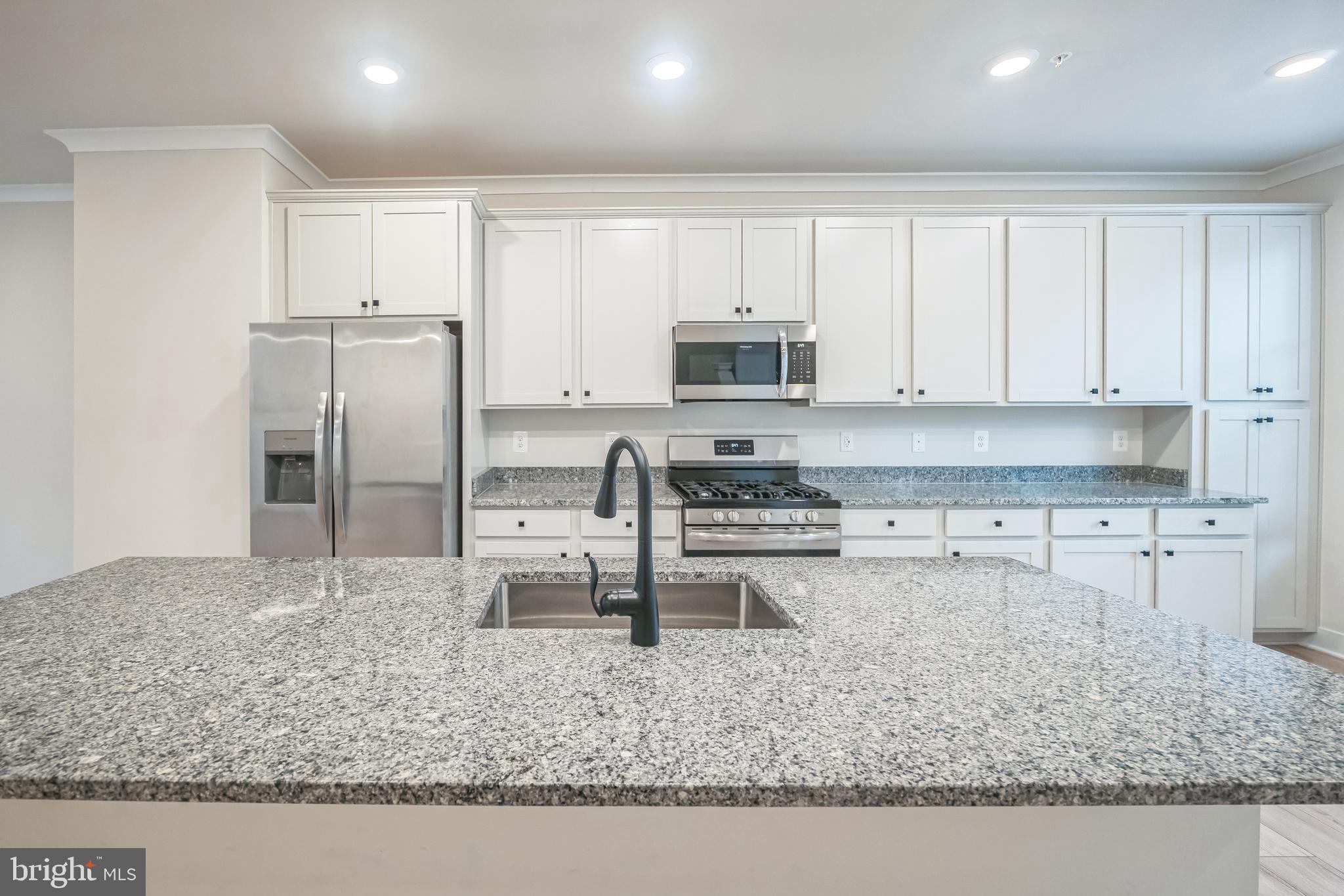4402 Roland Heights Avenue Baltimore, MD 21211 - Photo 20 of 47 a kitchen with stainless steel appliances granite countertop a sink stove and refrigerator