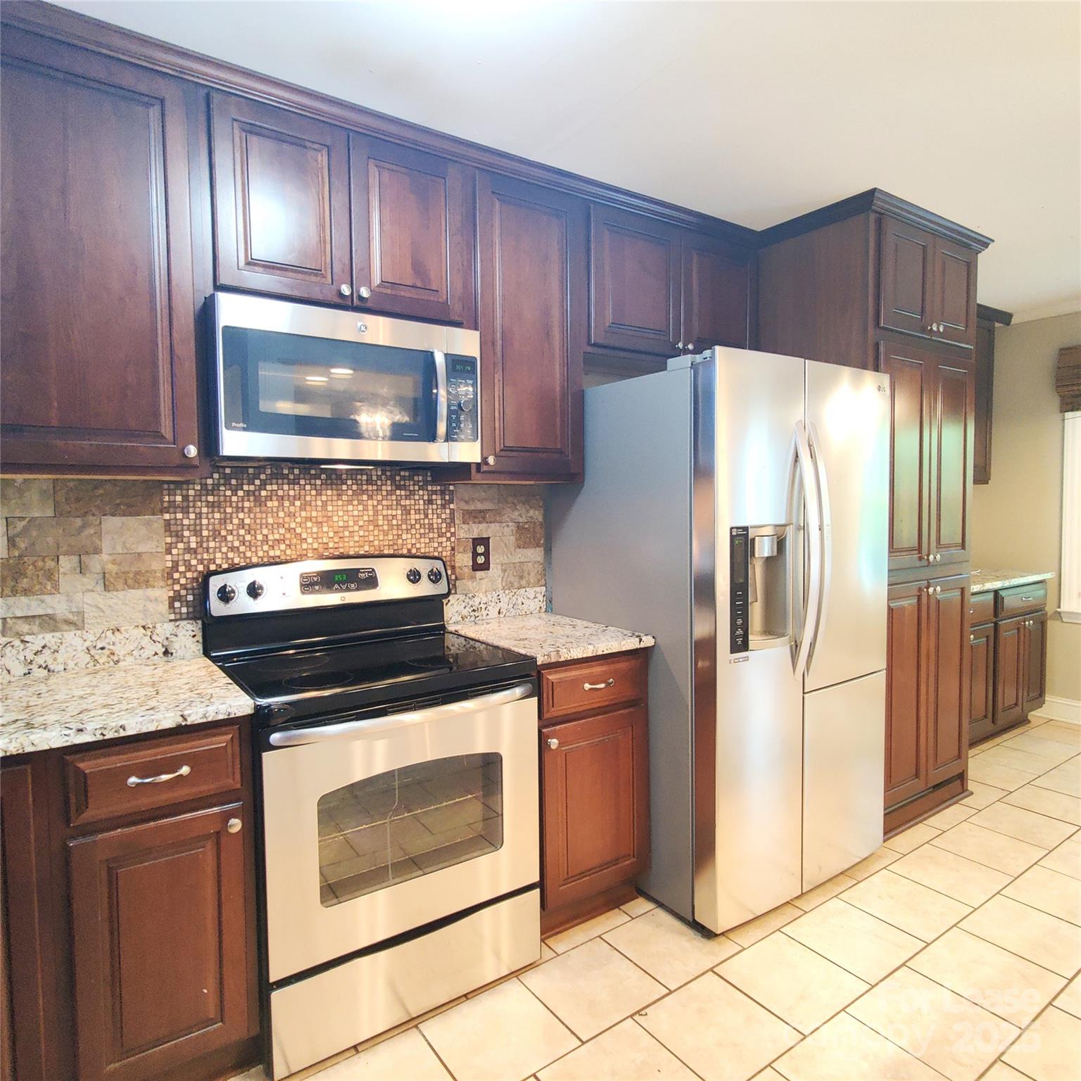 8644 Kirchenbaum Drive Charlotte, NC 28210 - Photo 3 of 28 a kitchen with granite countertop wooden cabinets stainless steel appliances and a counter space