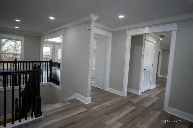 a view of hallway with a window and wooden floor