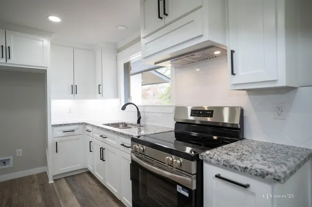 a kitchen with a sink stove top oven and cabinets