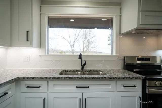 a kitchen with granite countertop a stove a sink and a granite counter tops