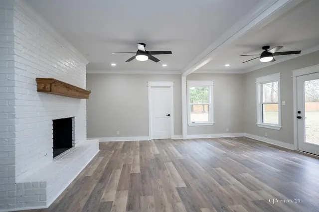 a view of empty room with wooden floor and fireplace