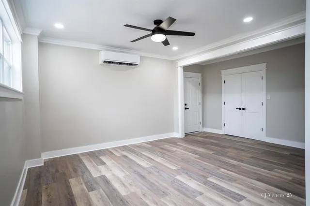 a view of empty room with wooden floor and fan