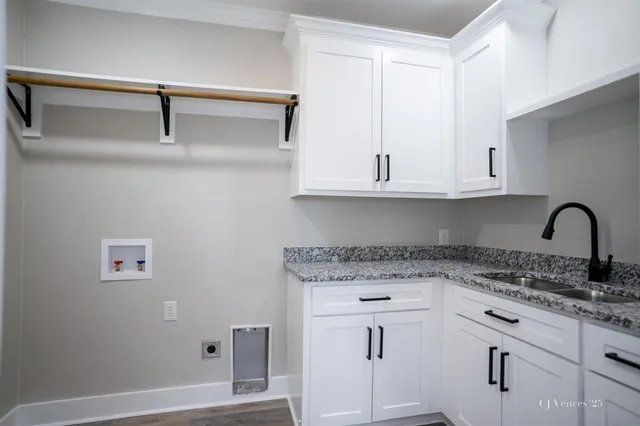 a kitchen with granite countertop white cabinets and sink