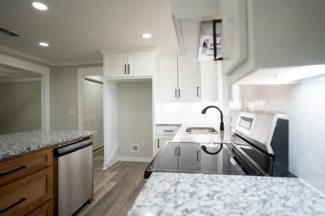 a kitchen with stainless steel appliances cabinets a sink and a stove
