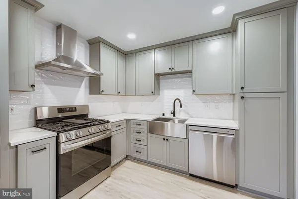 a kitchen with cabinets stainless steel appliances and a counter space