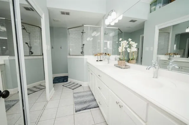 a bathroom with double sink and two mirror