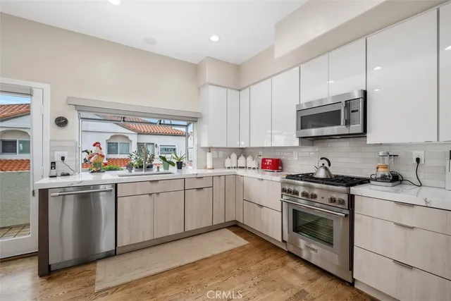 a kitchen with cabinets stainless steel appliances and a window
