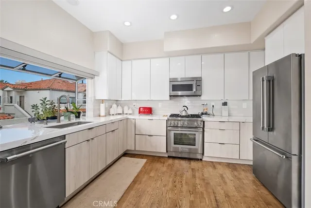 a kitchen with stainless steel appliances a sink stove and cabinets