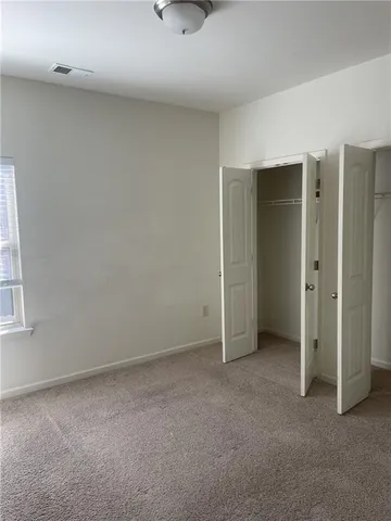 an empty room with windows and closet