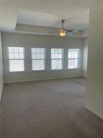 en empty room with windows and ceiling fan