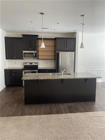 a kitchen with stainless steel appliances granite countertop a stove a sink and a refrigerator