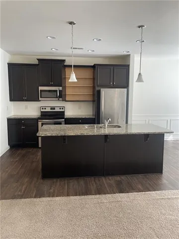 a kitchen with stainless steel appliances granite countertop a stove a sink and a refrigerator