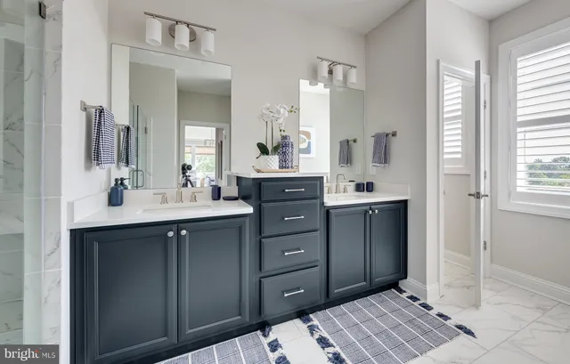 a spacious bathroom with a double vanity sink a mirror and a shower
