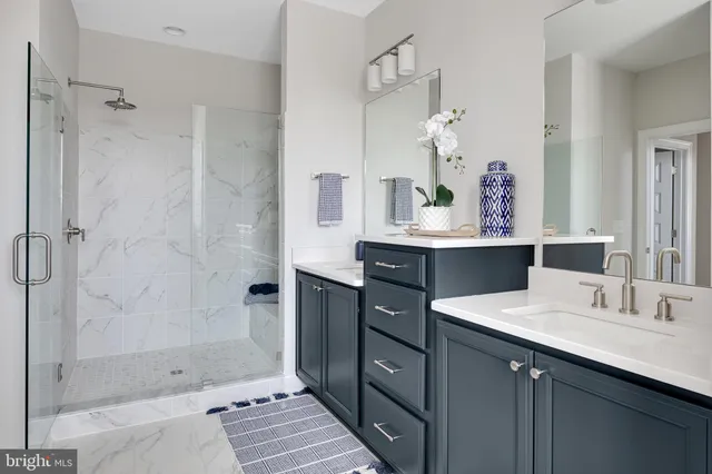 a bathroom with a double vanity sink mirror and shower