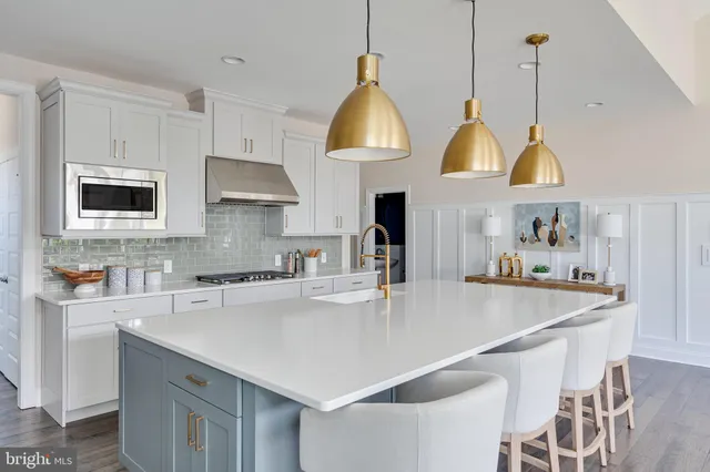 a kitchen with stainless steel appliances a stove a sink a microwave a refrigerator and cabinets