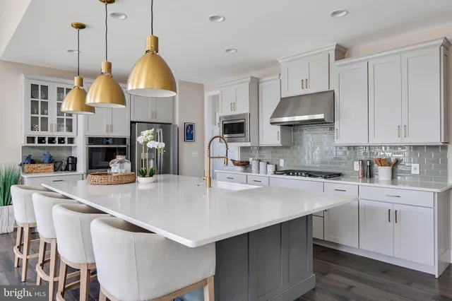 a kitchen with stainless steel appliances granite countertop a stove a sink a microwave a center island and a stove