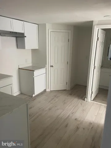 a view of a kitchen with white cabinets and refrigerator