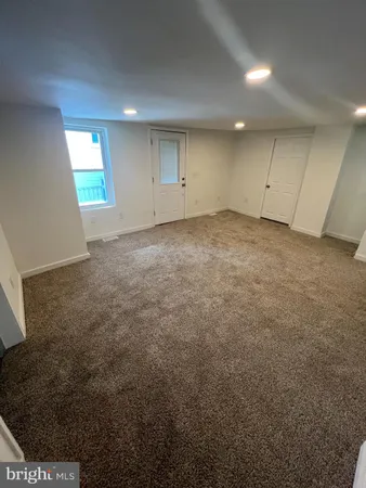 an empty room with an entryway and window
