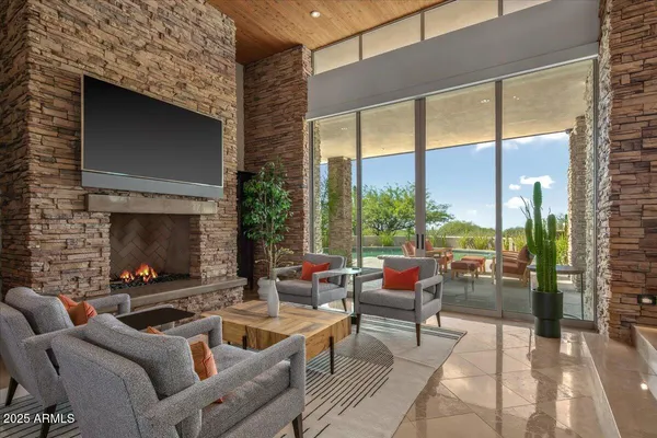 a living room with fireplace furniture and a large window