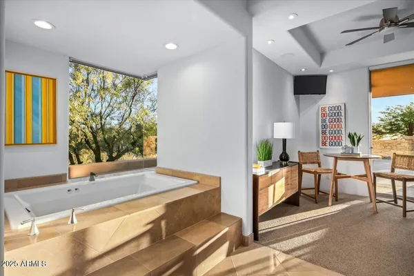 a living room with furniture a flat screen tv and floor to ceiling window