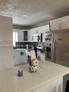 1025 West 77th Street, Unit N Hialeah, FL 33014 - Photo 10 of 30 a kitchen with a refrigerator a stove a sink and cabinets