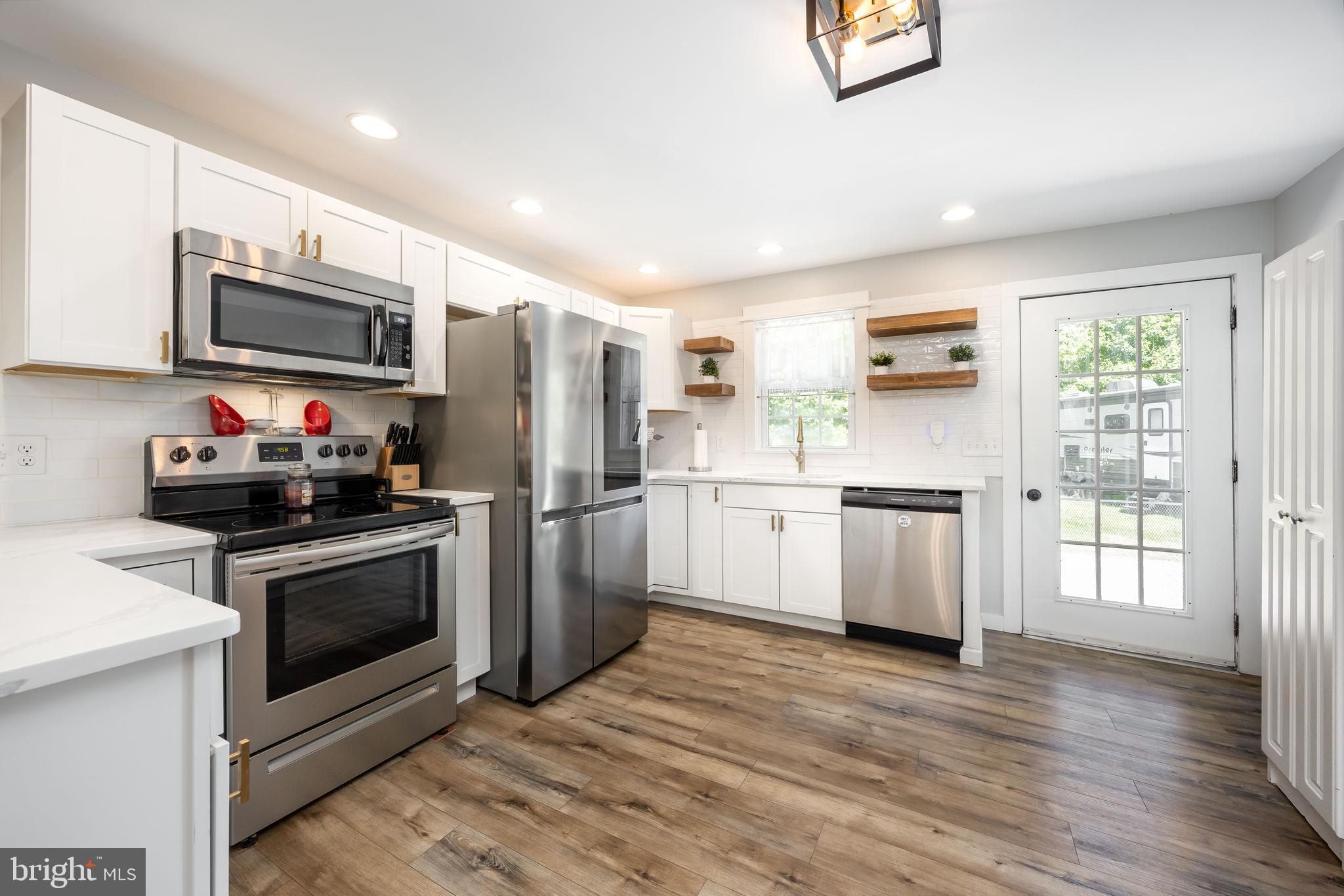 23078 Nanticoke Road Quantico, MD 21856 - Photo 22 of 67 a kitchen with a sink cabinets stainless steel appliances and wooden floor
