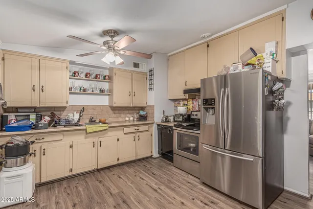 a kitchen with stainless steel appliances wooden floor sink and wooden cabinets