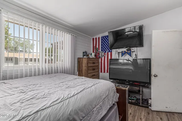 a bedroom with a bed and a flat screen tv