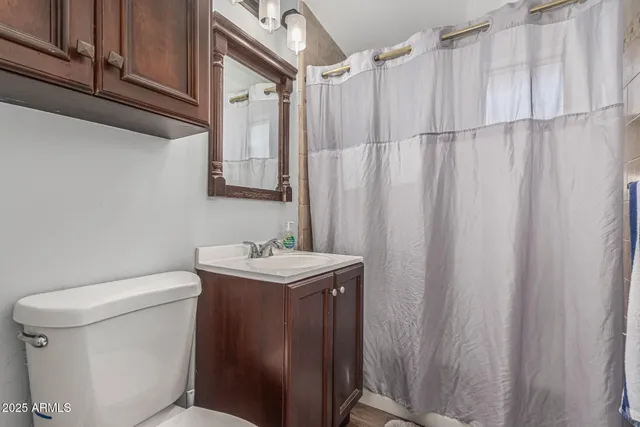 a bedroom with a bed and a flat tv screen on the dresser