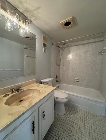 a bathroom with a granite countertop sink a toilet a mirror a bathtub and shower