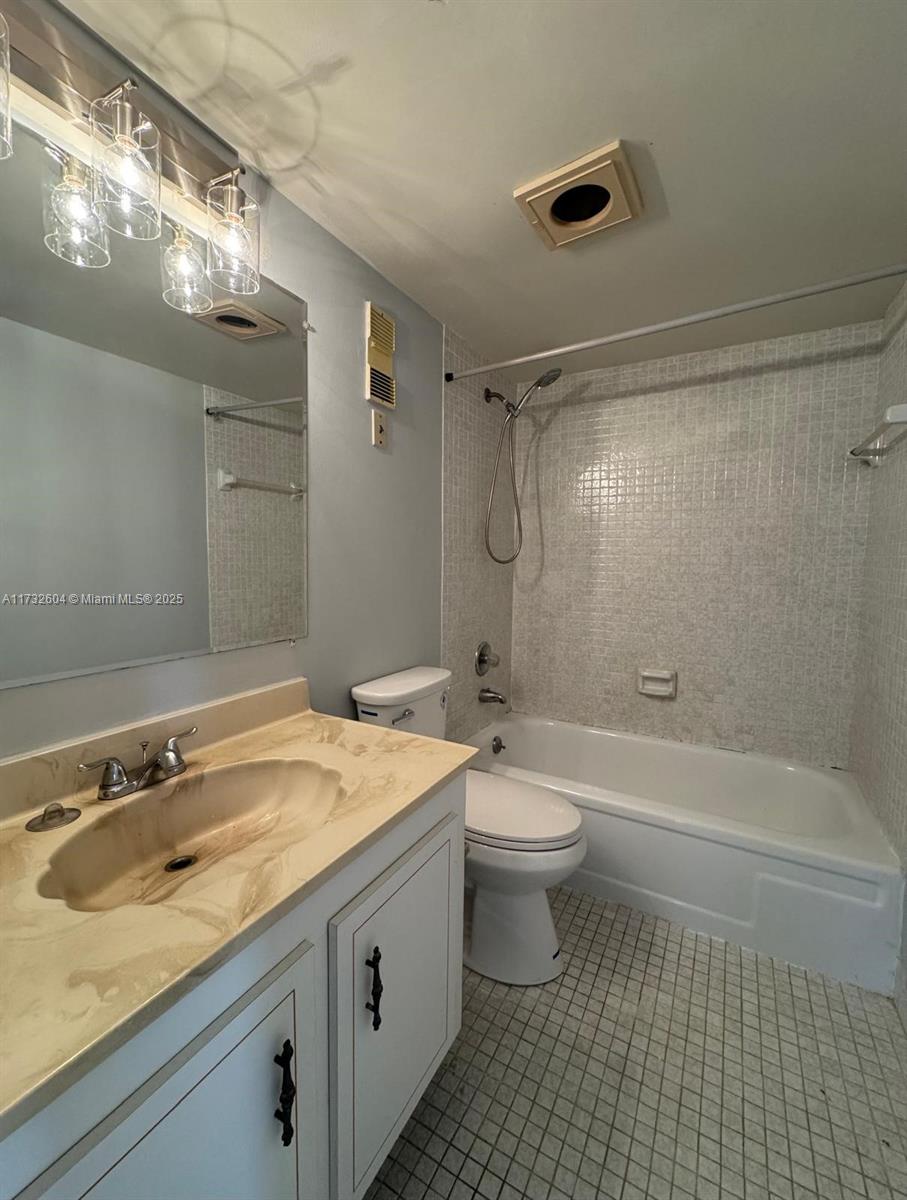 1200 St Charles Place, Unit 419 Pembroke Pines, FL 33026 - Photo 12 of 16 a bathroom with a granite countertop sink a toilet a mirror a bathtub and shower
