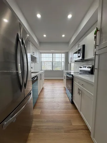 a large kitchen with stainless steel appliances lots of counter top space
