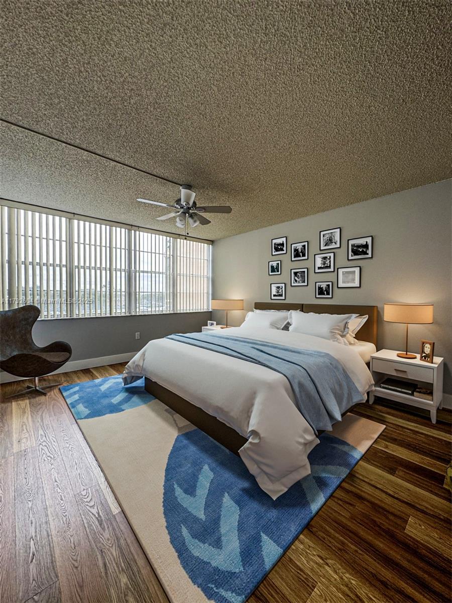 1200 St Charles Place, Unit 419 Pembroke Pines, FL 33026 - Photo 8 of 16 a bedroom with a bed and wooden floor