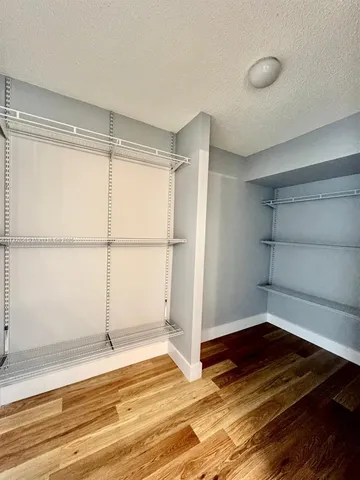 a view of a room with wooden floor and a window