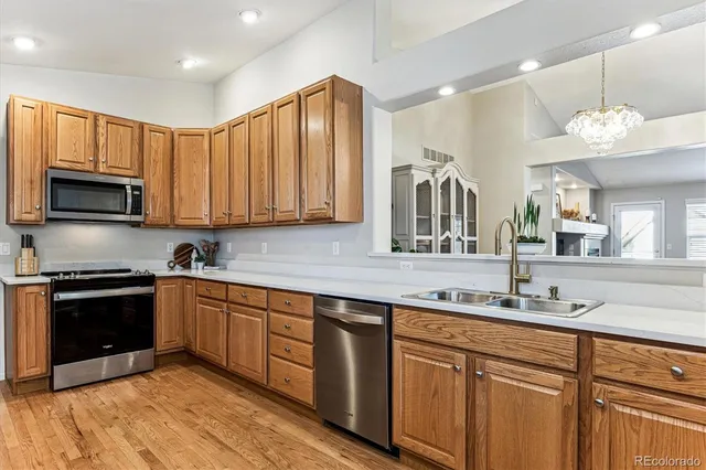 a kitchen with stainless steel appliances granite countertop wooden cabinets a stove top oven a sink and dishwasher