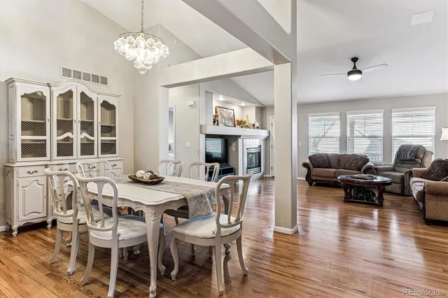a view of a dining room with furniture a chandelier and wooden floor