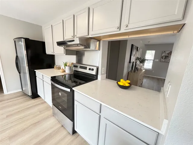 a kitchen with stainless steel appliances and white cabinets